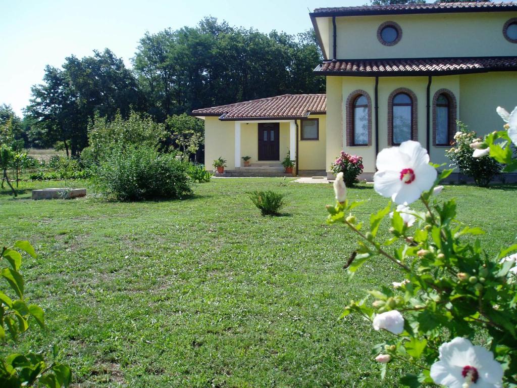 a small yellow house with a flower in the yard at Apartment studio TA-TI in Umag