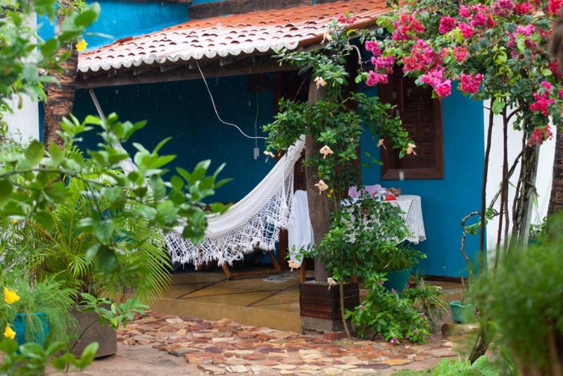 a blue house with a gazebo with flowers at Pousada Bangalô in Jericoacoara