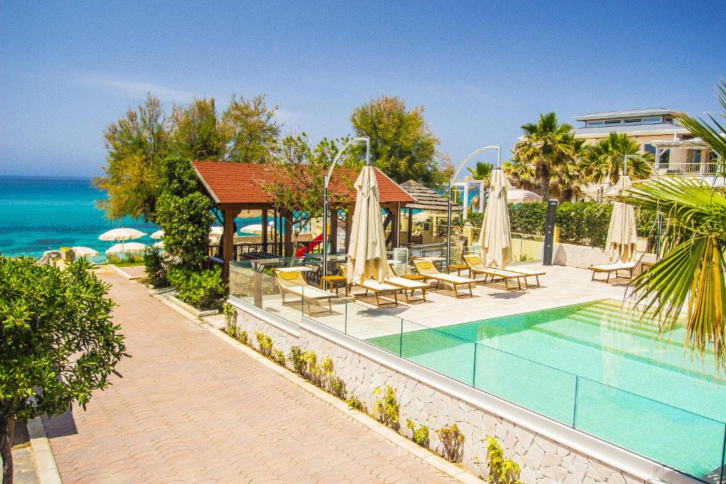 um resort com uma piscina com cadeiras e guarda-sóis em Villaggio Tramonto em Capo Vaticano