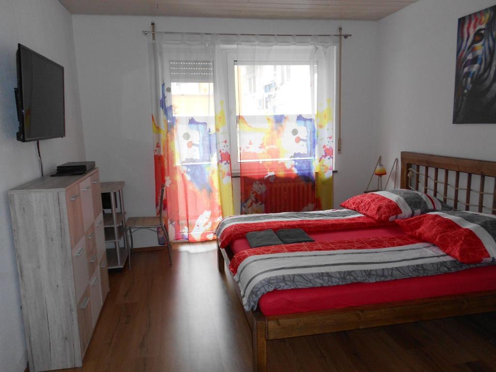 1 dormitorio con 2 camas, TV y ventana en Apartments Nikol - Ludwigshafen, en Ludwigshafen am Rhein