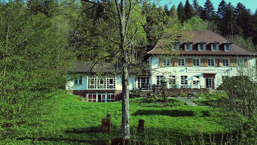 a house with a tree in the front yard at Gut Lauterbad Hotel in Freudenstadt