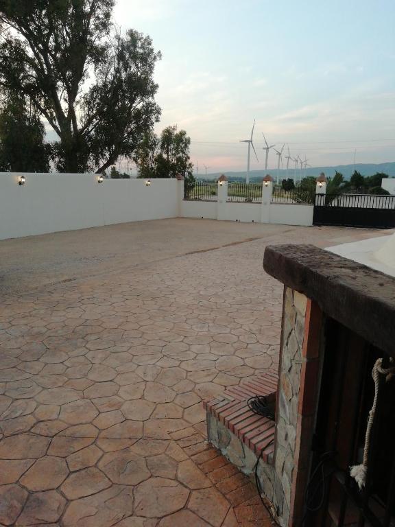 a stone patio with wind turbines in the background at Apartamentos Daper in Facinas