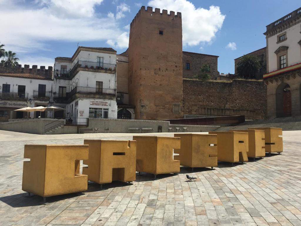 una fila de bancos amarillos en una calle de la ciudad en Vetonia Home, en Cáceres
