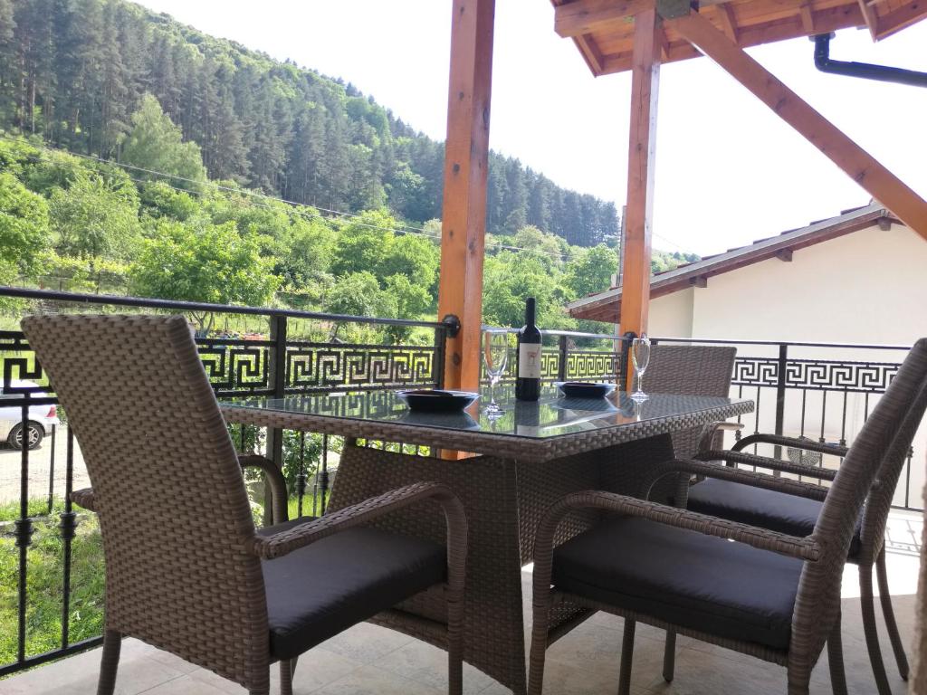 una mesa y sillas en un balcón con vistas en Forest Apartment, en Sapareva Banya