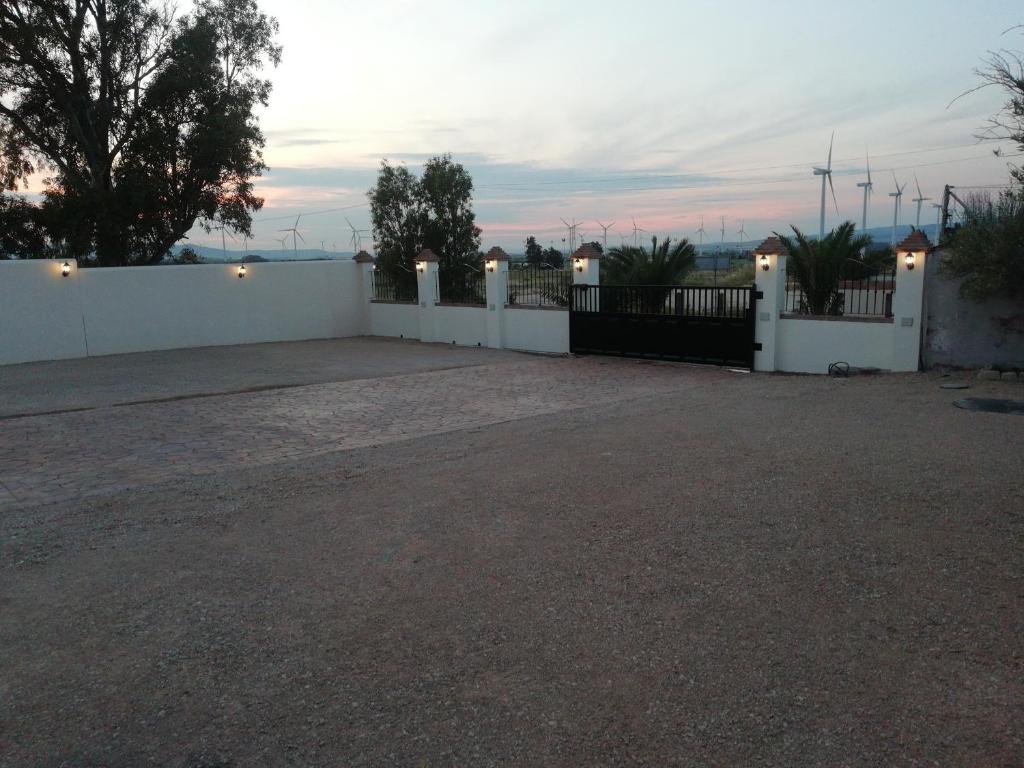 a house with a white fence and a driveway at Apartamentos Daper in Facinas