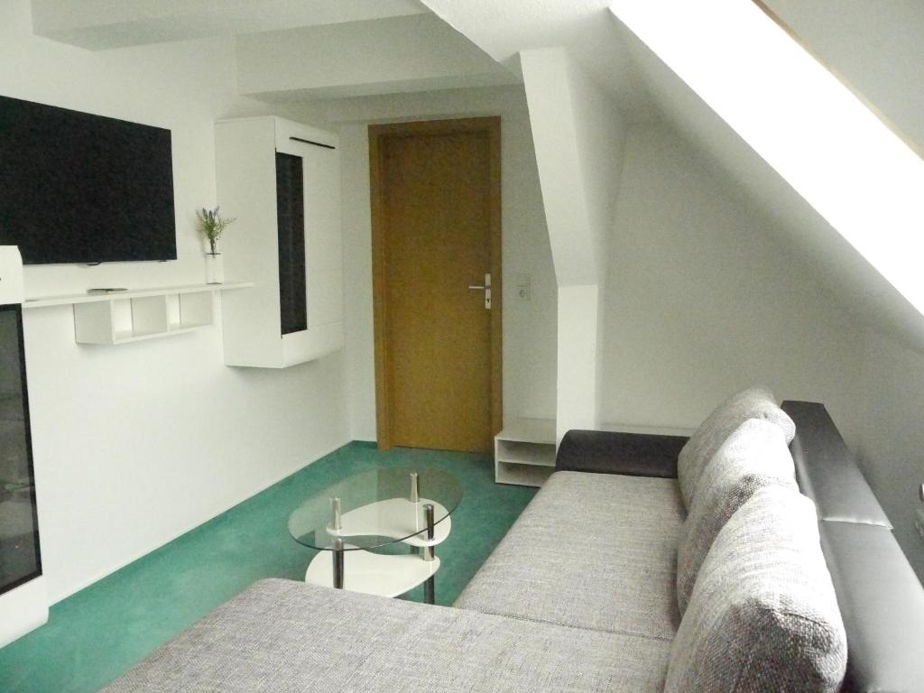 a living room with a couch and a table at Apart Pension Plaue in Brandenburg an der Havel