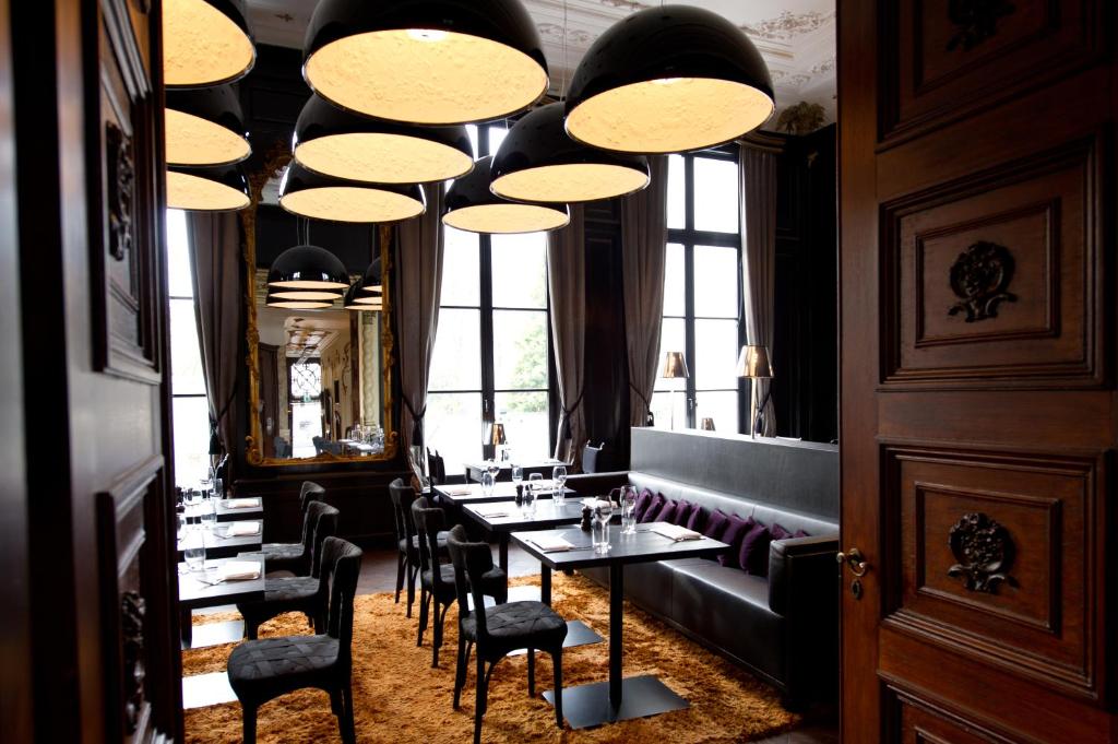 a dining room with tables and chairs and chandeliers at Canal House in Amsterdam