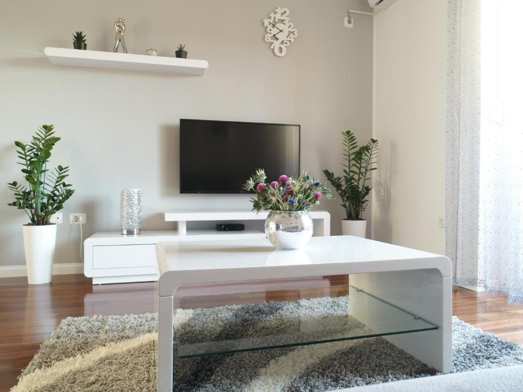 un soggiorno con tavolo bianco e TV di Cornial a Pola (Pula)