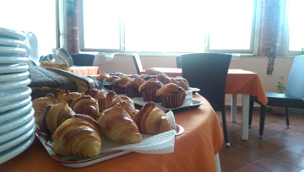 a table with a tray of pastries and muffins on it at Maria Tindara "La Locanda" in Vulcano