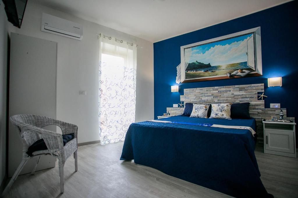a blue bedroom with a bed and a painting on the wall at La casa del pescatore in Oliveri