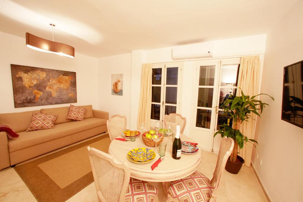 salon ze stołem i kanapą w obiekcie Casa Volare- estilo y relax en pleno casco antiguo w Maladze