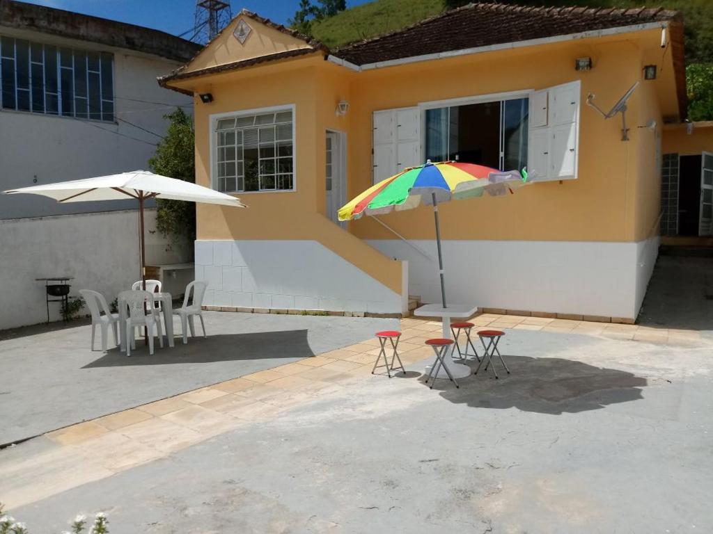 een patio met een tafel en stoelen en een parasol bij Coração do Centro in Conservatória