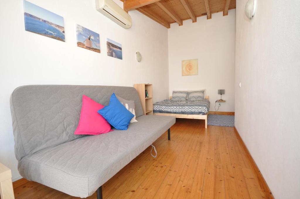 a living room with a gray couch with two colorful pillows at Casa Azul in Barão de São João