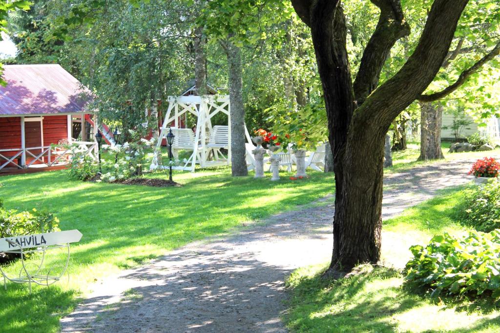 un patio con un árbol y un cenador en Eräjärven Eerola aittahuone (summer room), en Eräjärvi