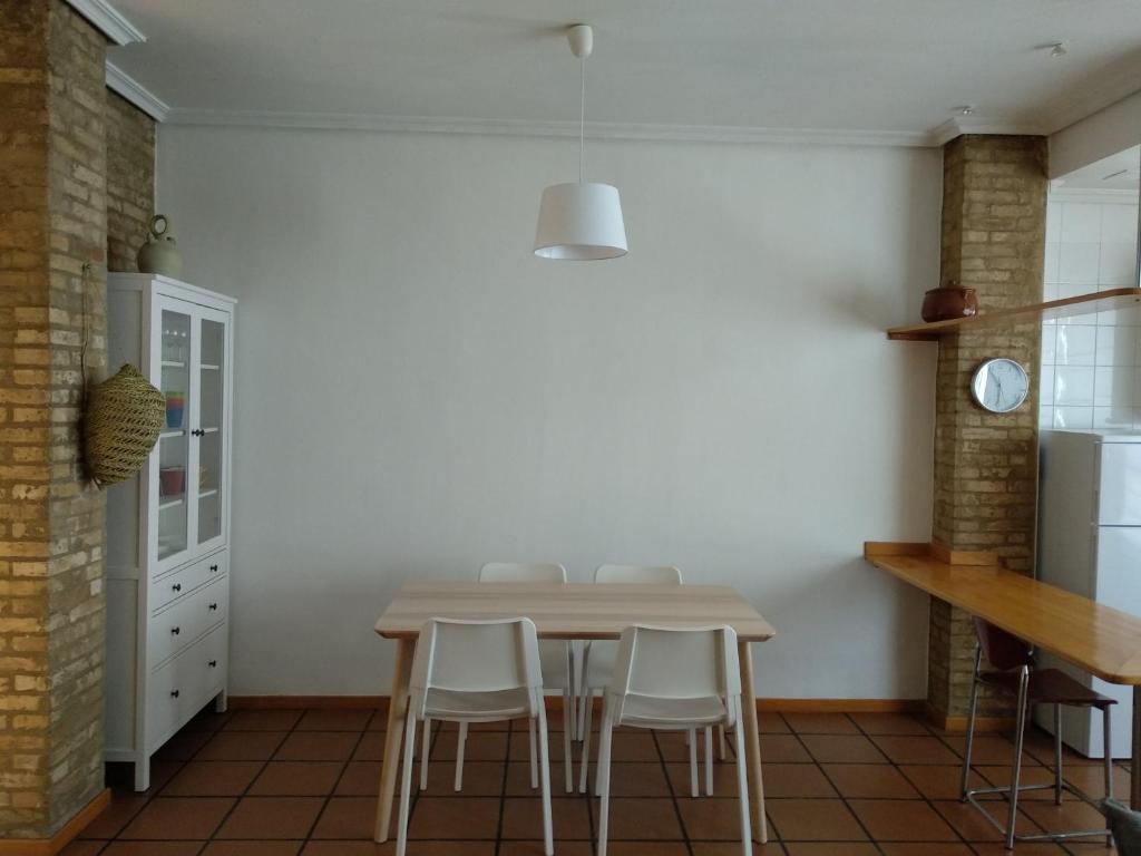 瓦倫西亞的住宿－Apartamento con estilo，厨房配有桌子和一些白色的椅子