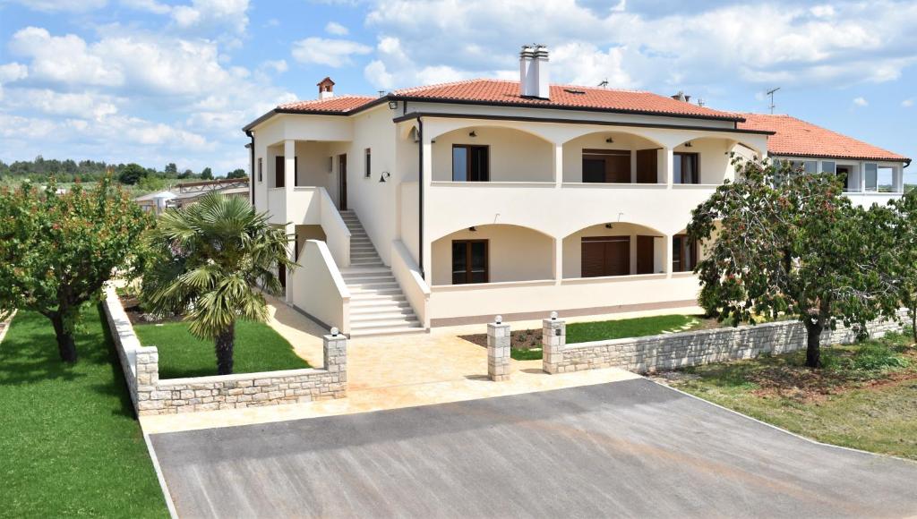 una gran casa blanca con entrada en Apartmani Diana en Novigrad Istria