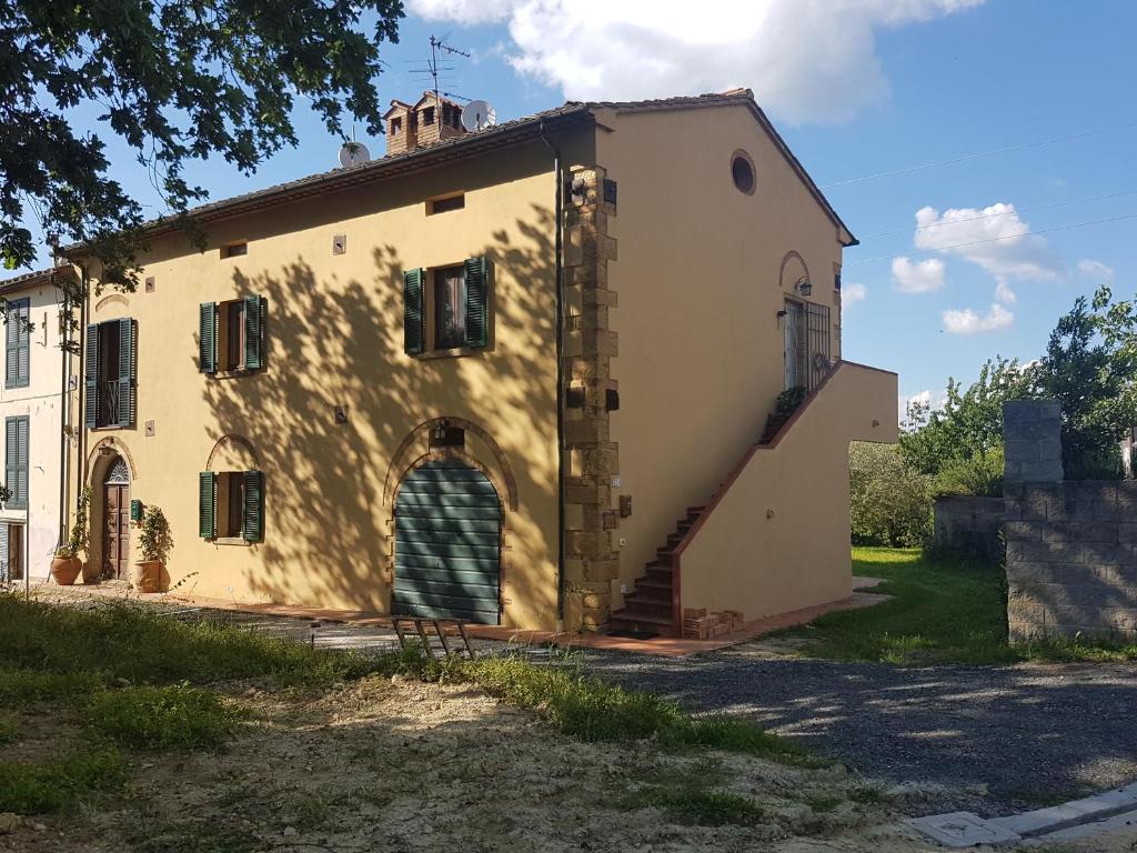 un edificio antiguo con una escalera que conduce a él en La Bellana, en Guardistallo