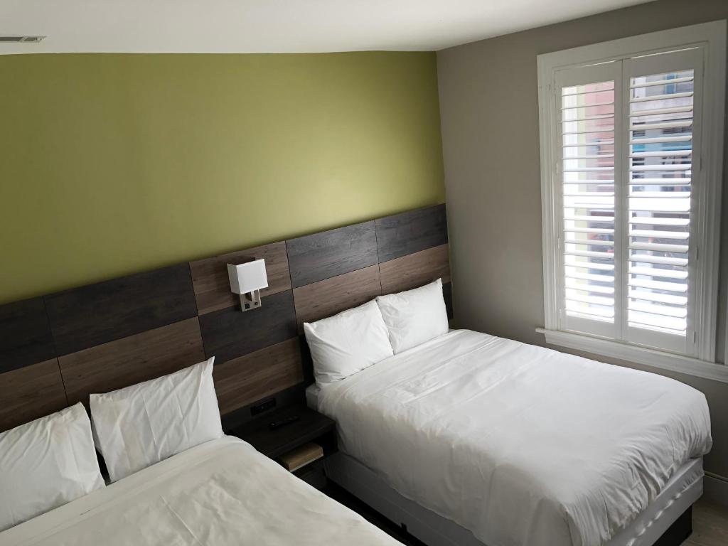 een slaapkamer met 2 bedden en een raam bij Bay Hotel in San Francisco