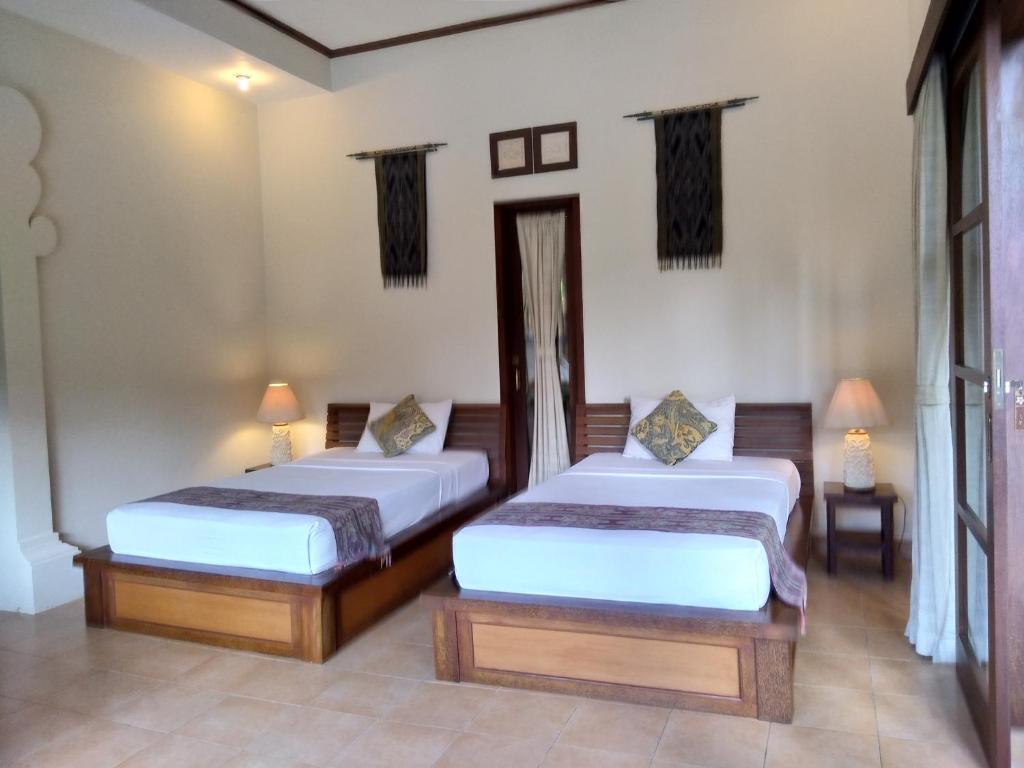 Postel nebo postele na pokoji v ubytování Ubud Lestari Bungalows
