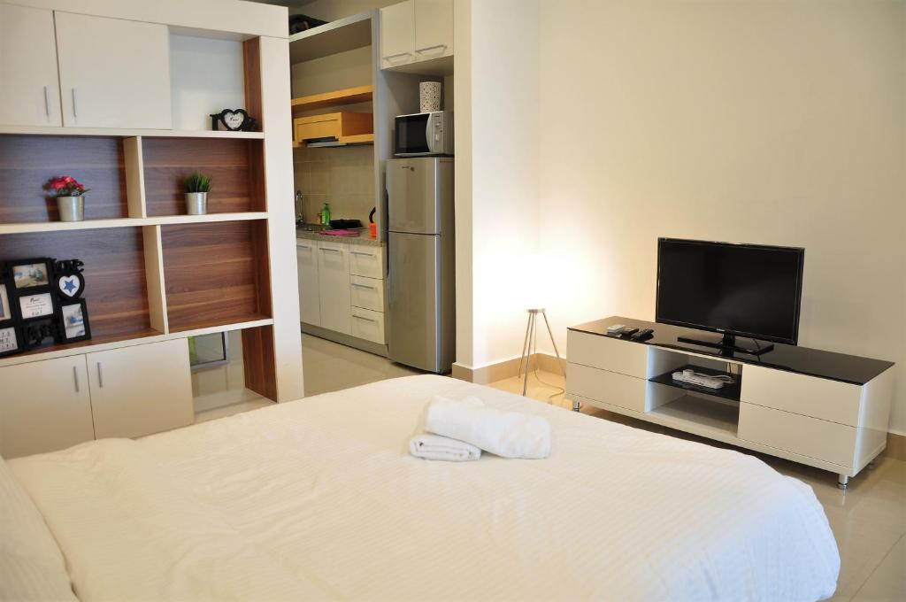 a small room with a bed and a television at Shaftsbury Cyberjaya by IdealHub in Cyberjaya
