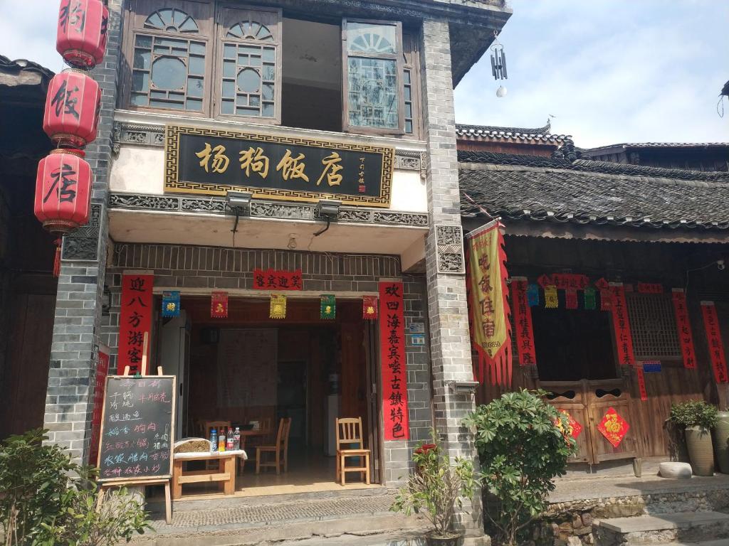 a building with a sign on the front of it at Xiasi Ancient Town Yang Gou Guesthouse in Xiasi