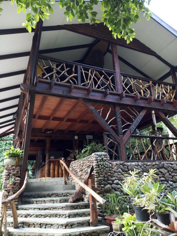una casa con una pared de piedra y escaleras en Haere Mai I Te Fare, en Teavaro