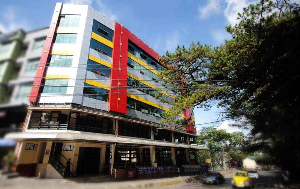 een hoog gebouw met een rood en geel bij Hotel 45 Extension in Baguio