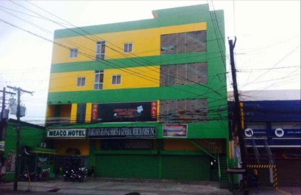ein gelbes und grünes Gebäude auf einer Straße in der Unterkunft Meaco Hotel - Solano in Solano
