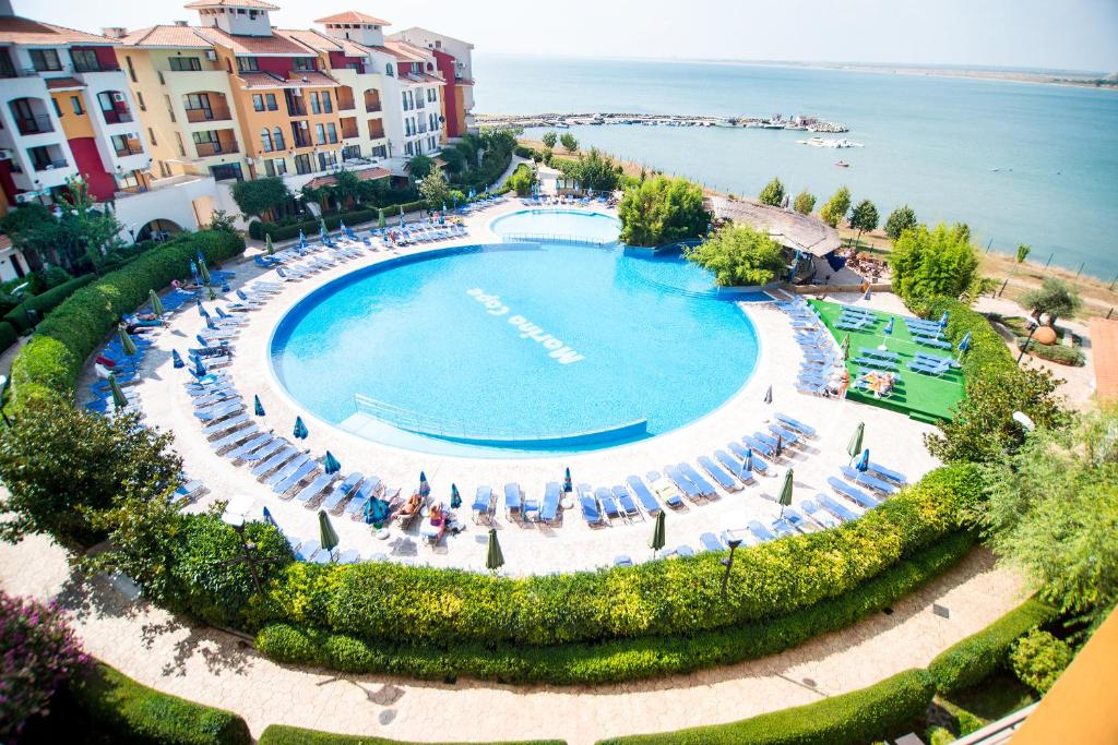 an overhead view of a large swimming pool next to the water at Marina Cape Vacation Complex in Ravda