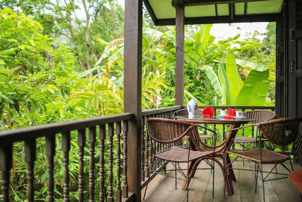 a balcony with a table and chairs on a porch at Villa Sri Kampung in Kuah