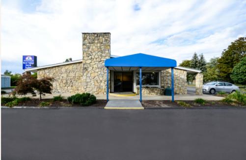 a building with a blue canopy in front of it at Americas Best Value Inn & Suites Jackson in Jackson
