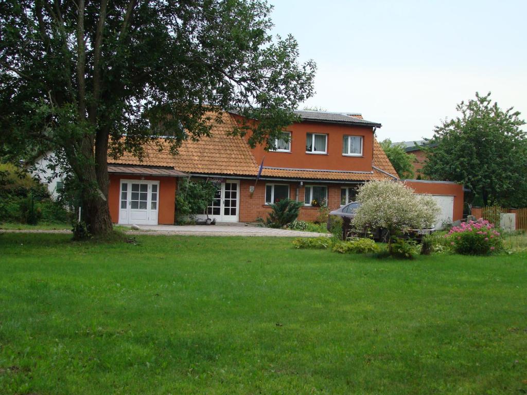 una casa con un árbol en un patio en Dana Guest House, en Roja