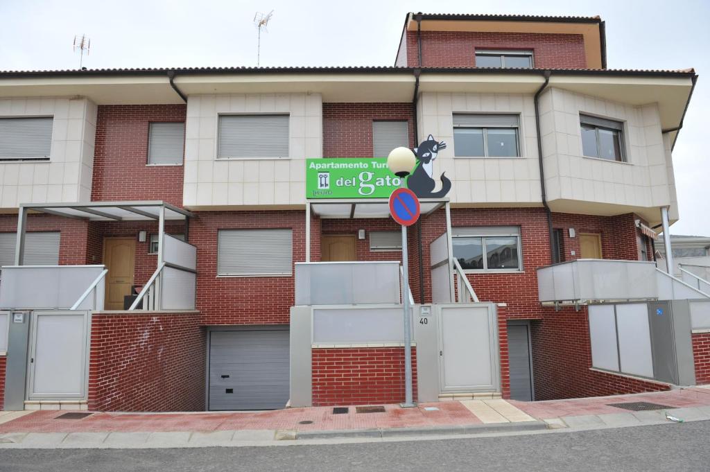 un edificio de ladrillo rojo con un letrero de la calle delante de él en Apartamento Turístico La Casa del Gato, en Azagra