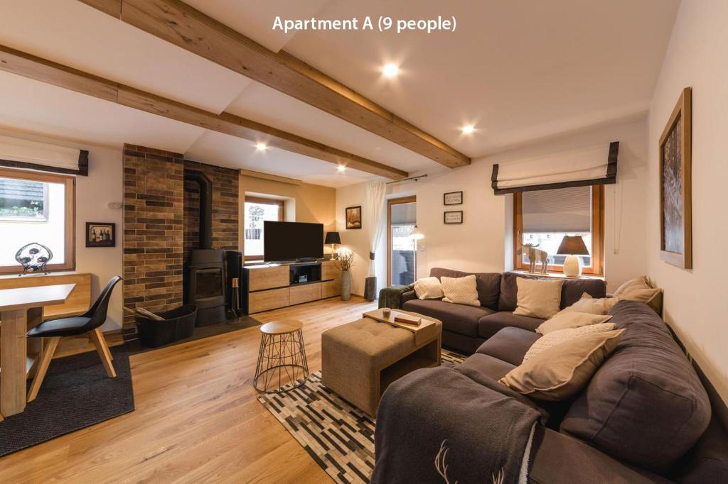 a living room with a couch and a tv at Luxury Chalet Mallnitz in Mallnitz