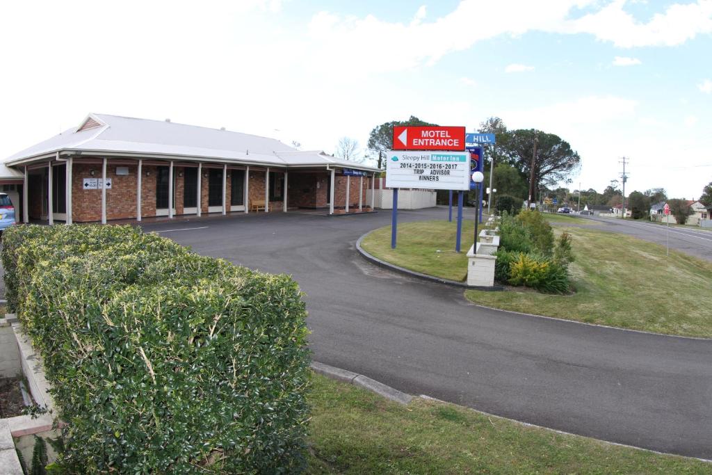 um edifício com uma placa na berma de uma estrada em Sleepy Hill Motor Inn em Raymond Terrace