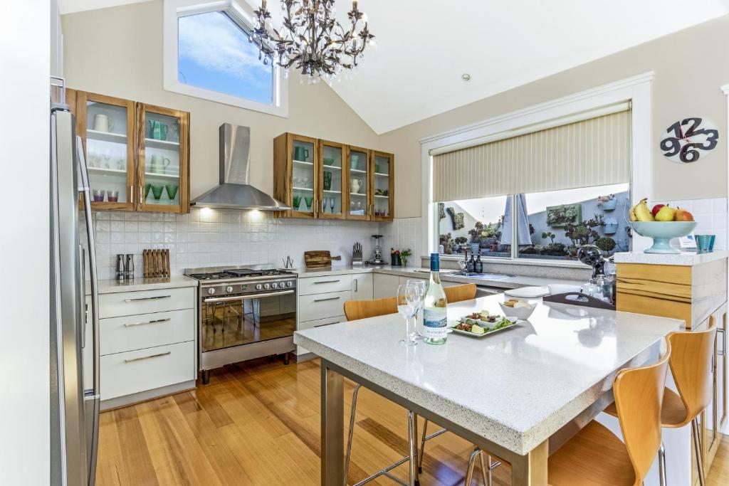 a kitchen with a white counter top and a table at Topiary Haven in Launceston