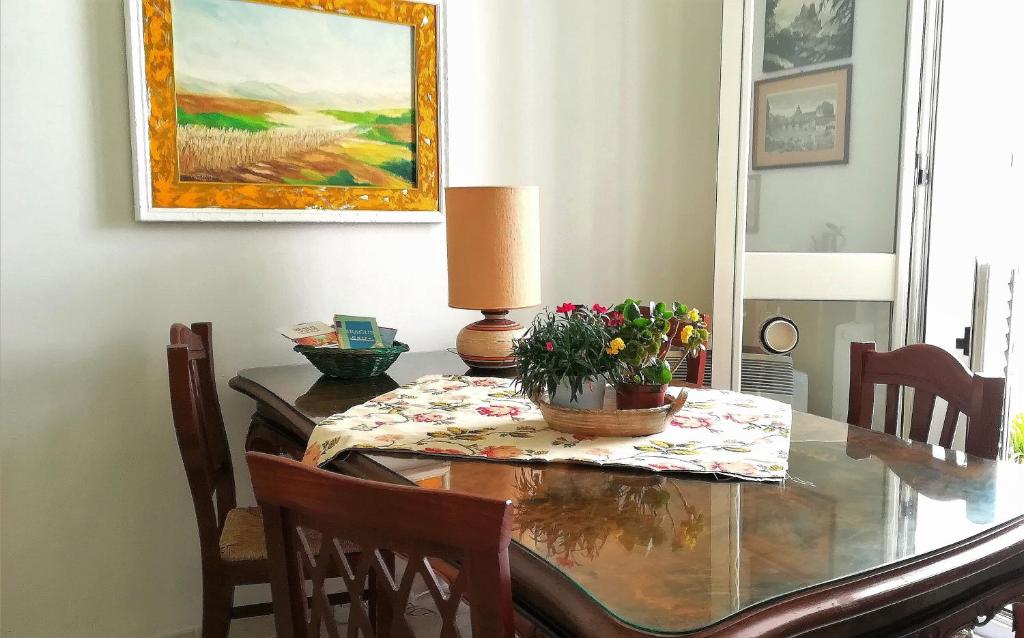 uma sala de jantar com uma mesa de vidro com flores em Casa Elena Al Duomo em Siracusa