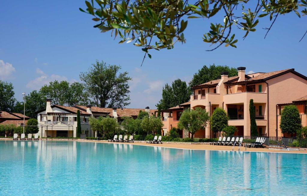 ペスキエーラ・デル・ガルダにあるEsclusivo trilocale con piscina al Garda Resort Villageの家の前の大型スイミングプール