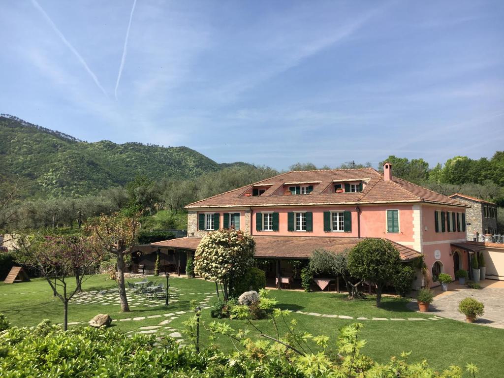 een groot huis met een tuin met groen gras bij Relais Borgofasceo in Ortovero