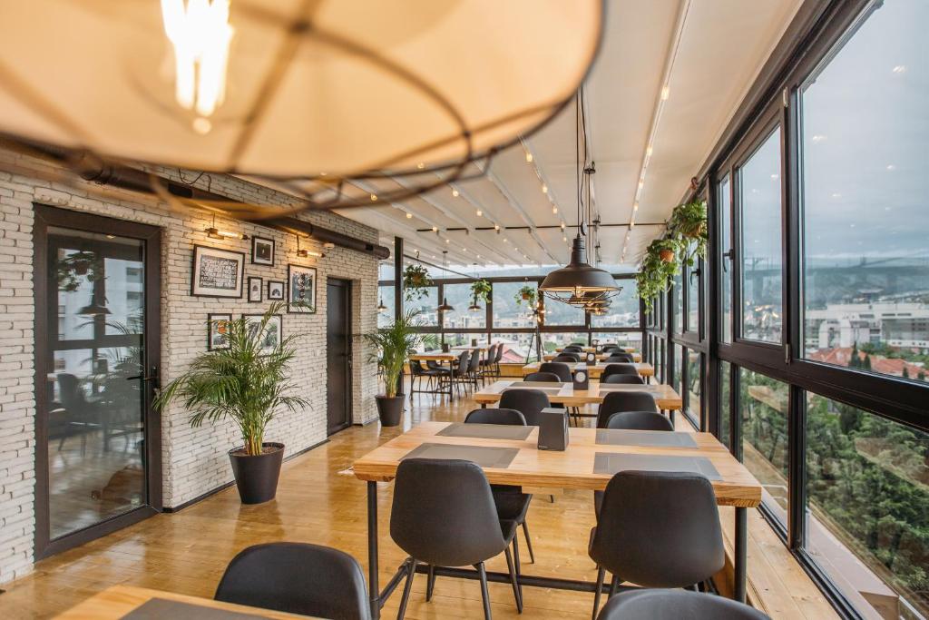 a row of tables and chairs in a room with windows at Timber Boutique Hotel in Tbilisi City