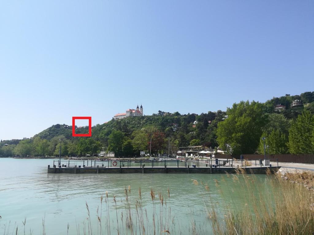 ティハニにあるCsizmazia Apartmanの湖上赤い物を持つ桟橋