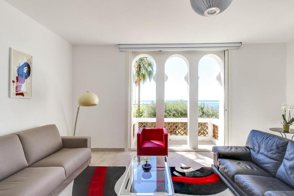 - un salon avec un canapé et un fauteuil rouge dans l'établissement Holiday Home with beautiful Sea View, au Golfe-Juan