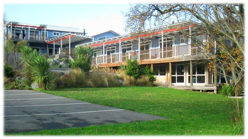 a large building with a lawn in front of it at The Lazy Shag Lodge in Kaikoura