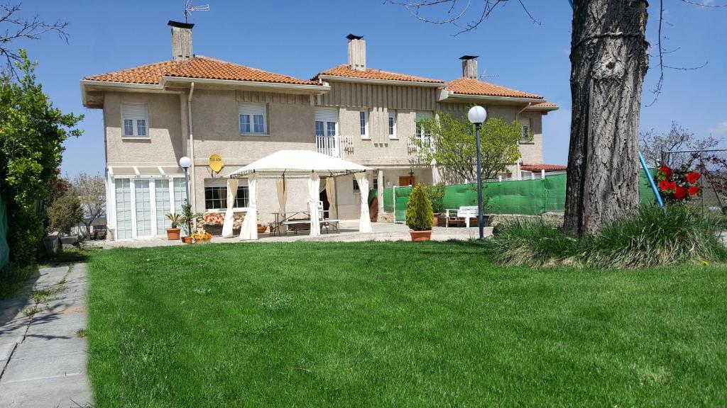 una grande casa con un prato davanti di Casa Bellavista a Segovia