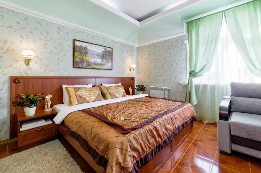 ein Hotelzimmer mit einem Bett und einem Stuhl in der Unterkunft Well House Hotel in Wolgograd