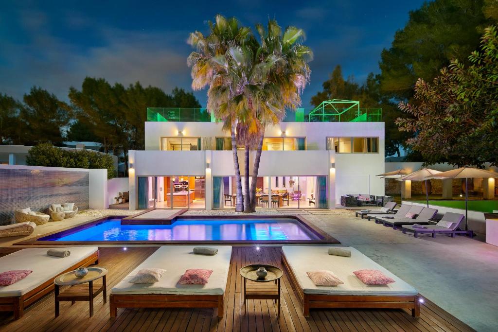 a house with a pool and a palm tree at Casa India Ibiza in Santa Eularia des Riu