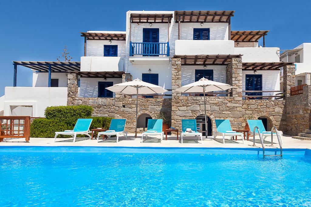 a villa with a swimming pool with chairs and umbrellas at San Antonio Summer House in Piso Livadi