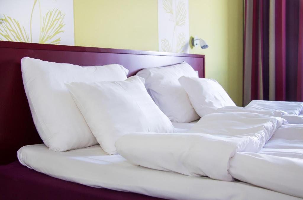 una cama con almohadas blancas encima en Hotel Salora, en Salo