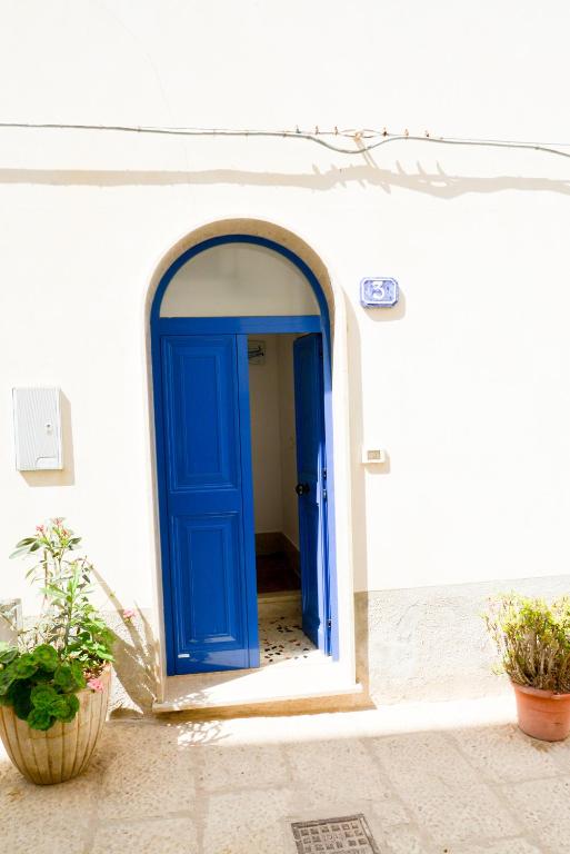 a blue door on the side of a white building at Casa Duran in Marettimo