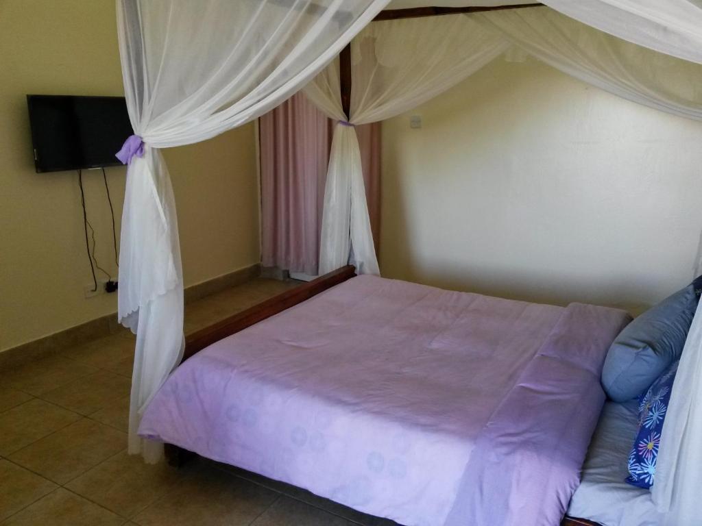 Postel nebo postele na pokoji v ubytování Mwanzo Lodge